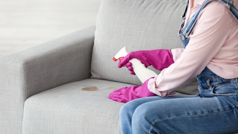 Woman,In,Gloves,Cleaning,Dirty,Stain,On,Sofa,At,Home